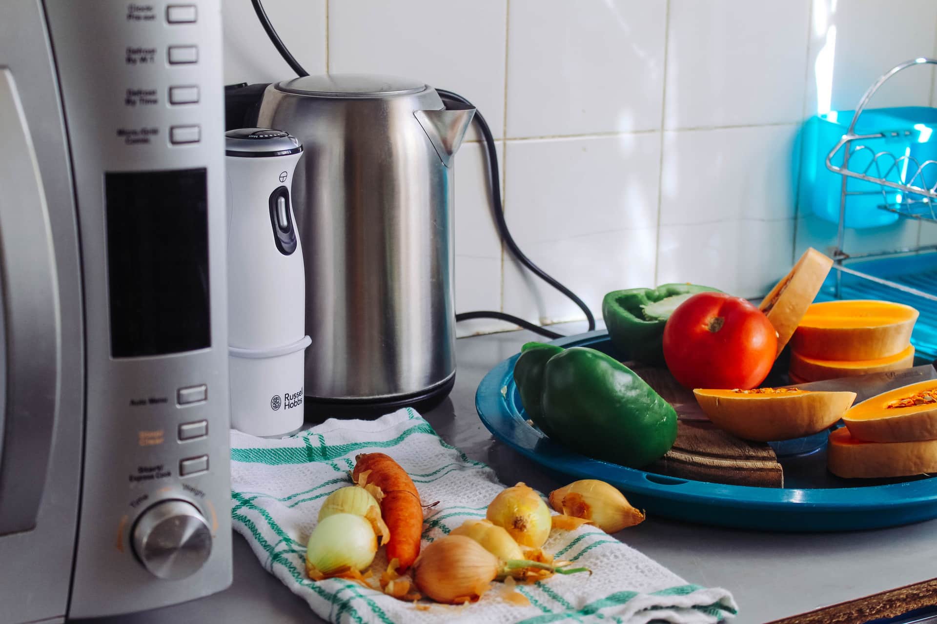 A stainless countertop ice maker photographed on a plain kitchen counter