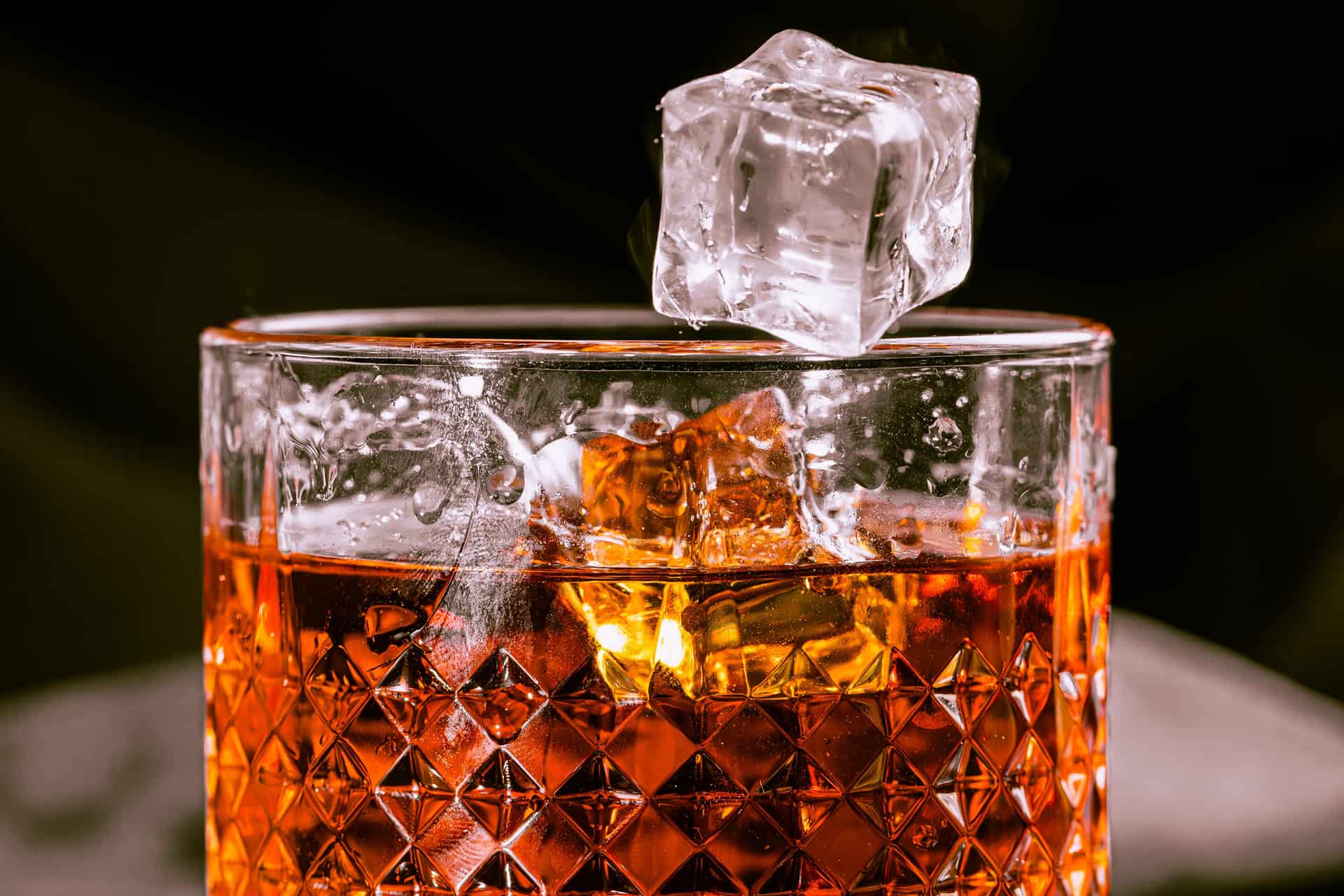 A cocktail served over a large clear ice cube